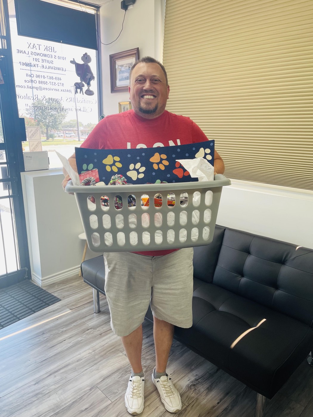 A client in the JBK Tax waiting room holding a prize basket from the yearly raffle.