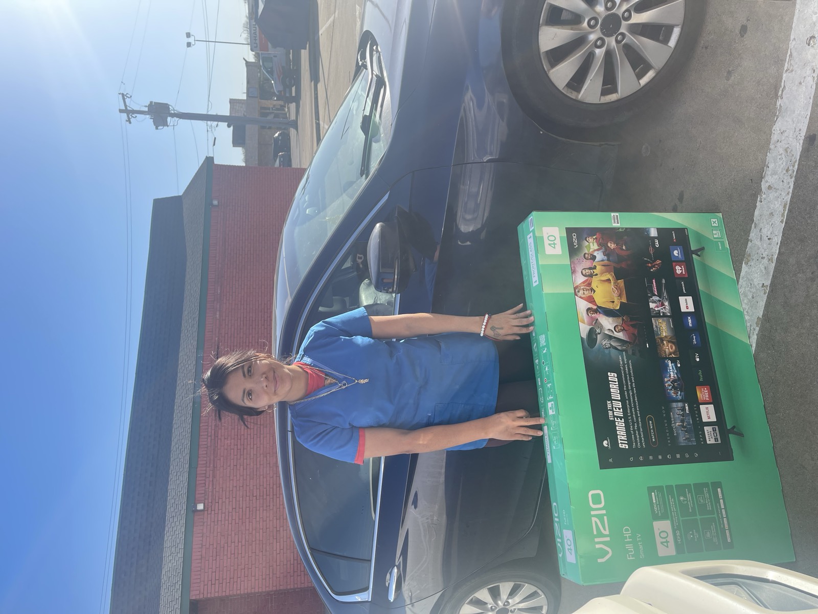 A client standing with the television she won in the JBK Tax yearly raffle.